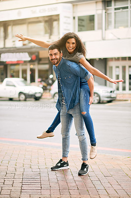 Buy stock photo Shot of a playful couple out in the city together
