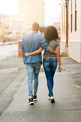 Buy stock photo Rearview shot of a young couple out walking in the city