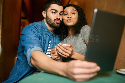 Buy stock photo Cropped shot of a young couple taking a selfie in a cafe