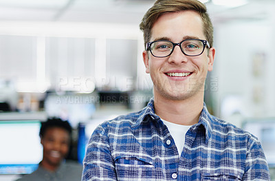 Buy stock photo Portrait of a smiling young designer standing in an office with colleagues working in the background