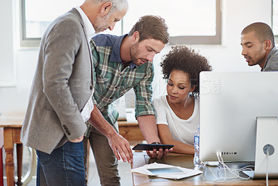 Buy stock photo Shot of a group of designers talking together over a digital tablet in an office