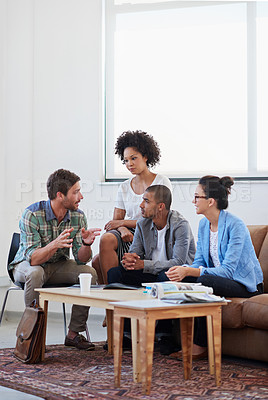 Buy stock photo Shot of a diverse group of young designers talking together while sitting on a sofa in an office