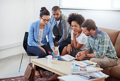 Buy stock photo Shot of a diverse group of young designers talking together while sitting on a sofa in an office