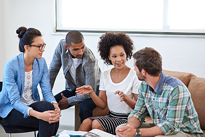 Buy stock photo Shot of a diverse group of young designers talking together while sitting on a sofa in an office