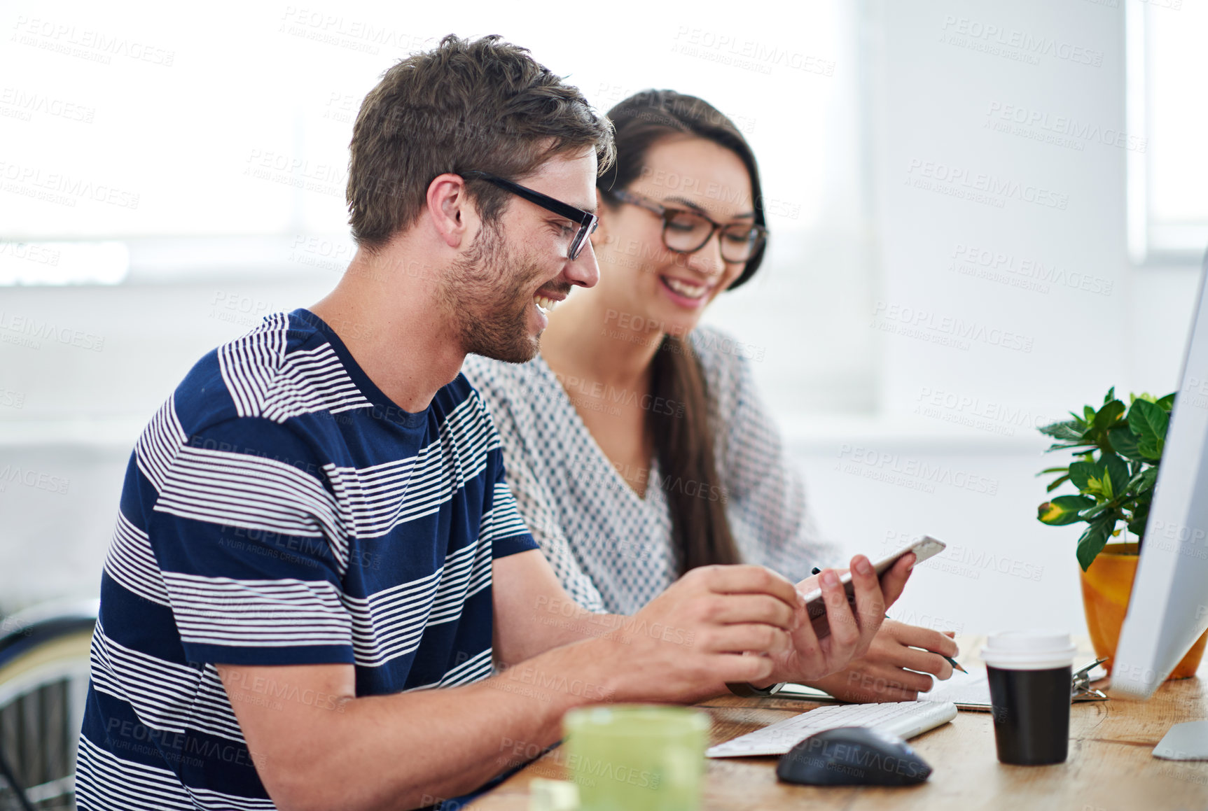 Buy stock photo Shot of two young designers talking together over a digital tablet in an office