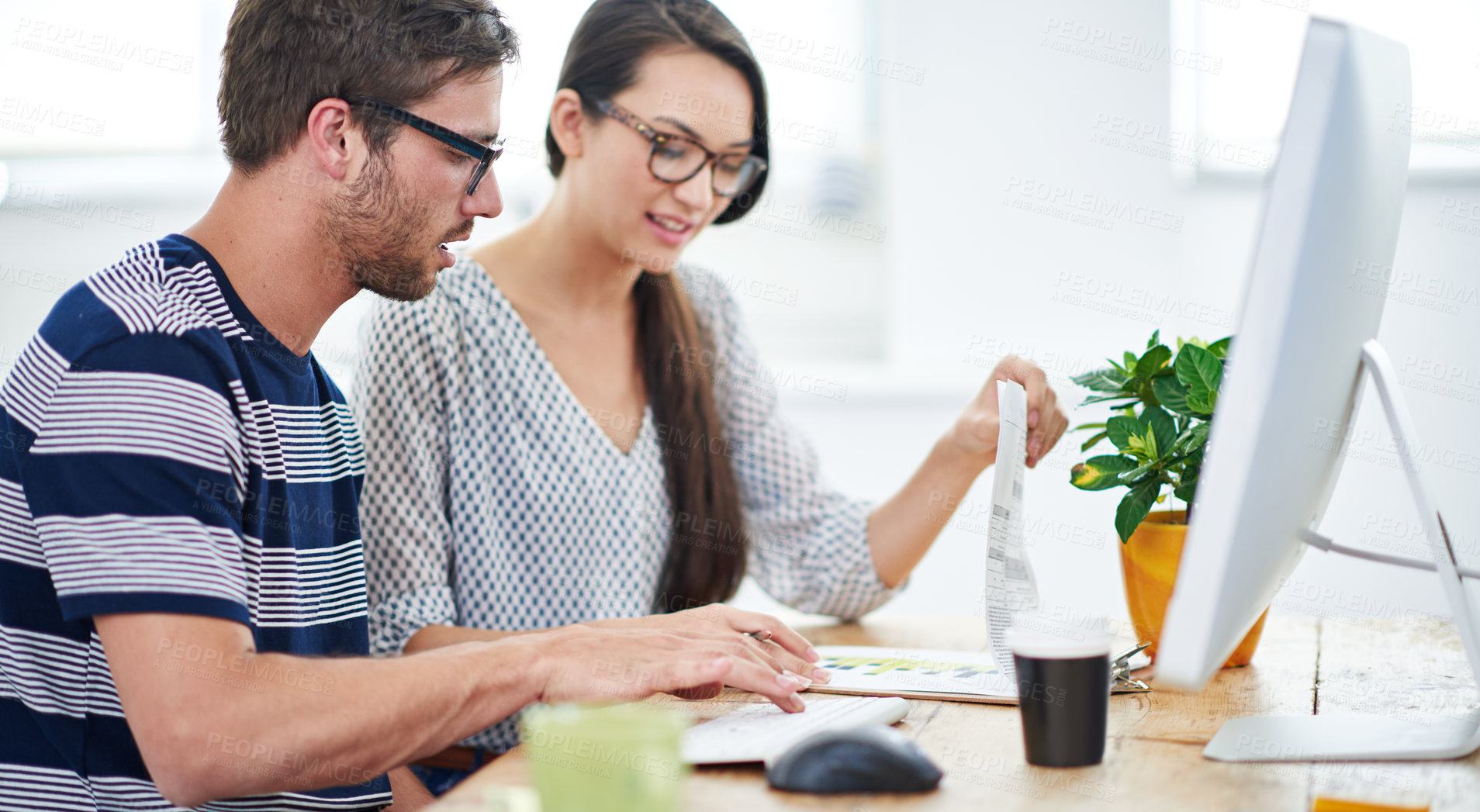 Buy stock photo Shot of two young designers talking together over a digital tablet in an office