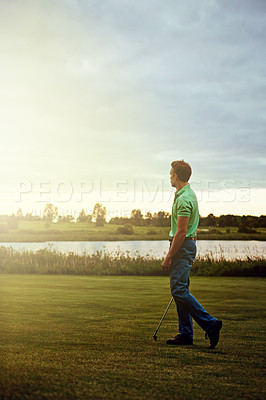 Buy stock photo Shot of a young man spending the day on a golf course