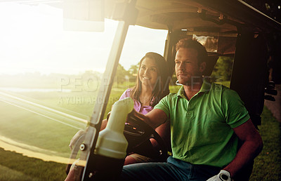 Buy stock photo Shot of a couple riding in a golf cart on a golf course