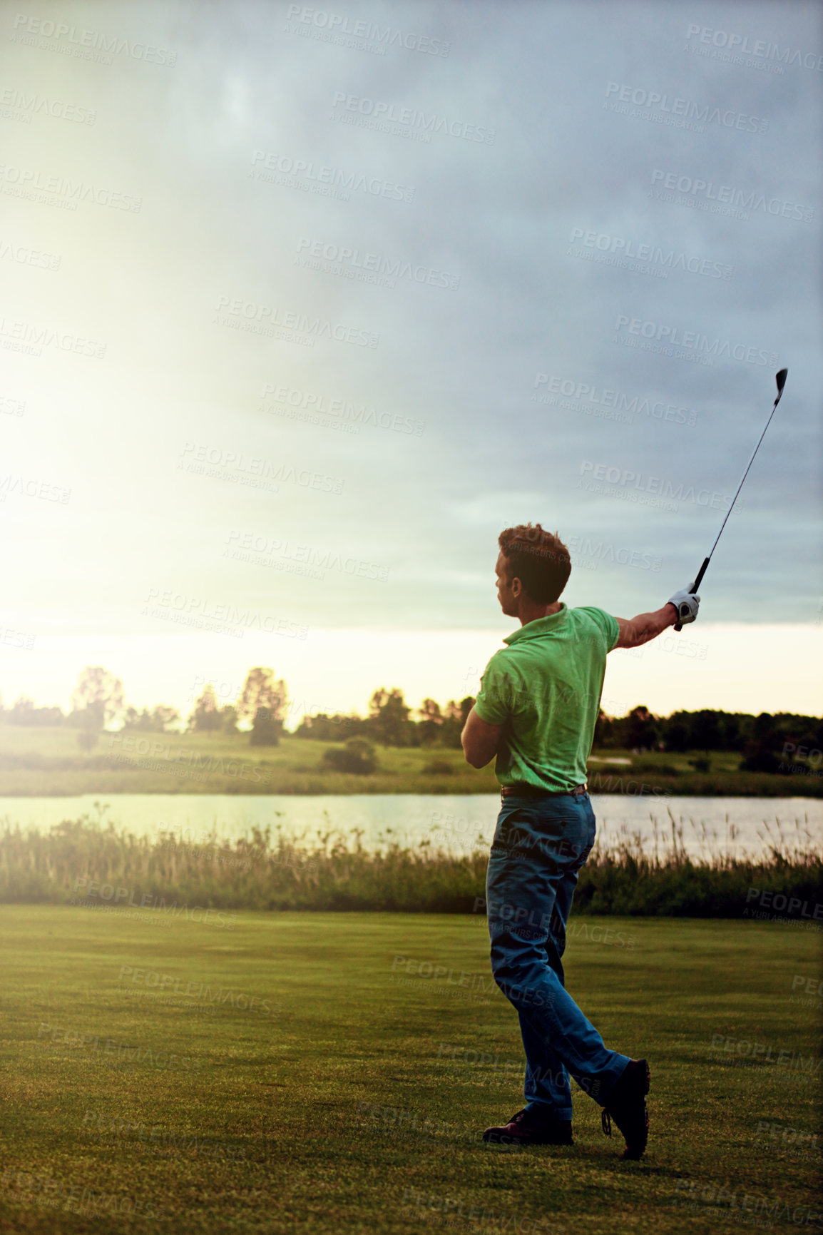 Buy stock photo Shot of a young man spending the day on a golf course