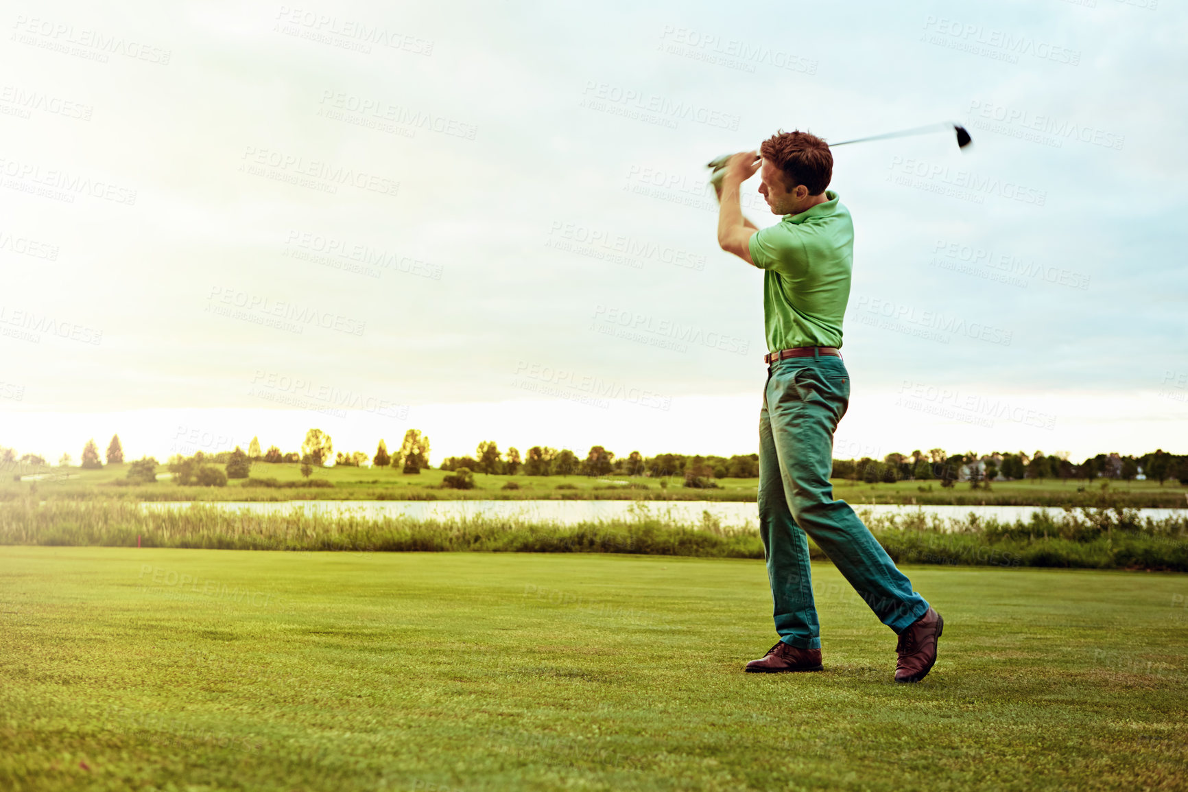 Buy stock photo Shot of a man practicing his swing on the golf course