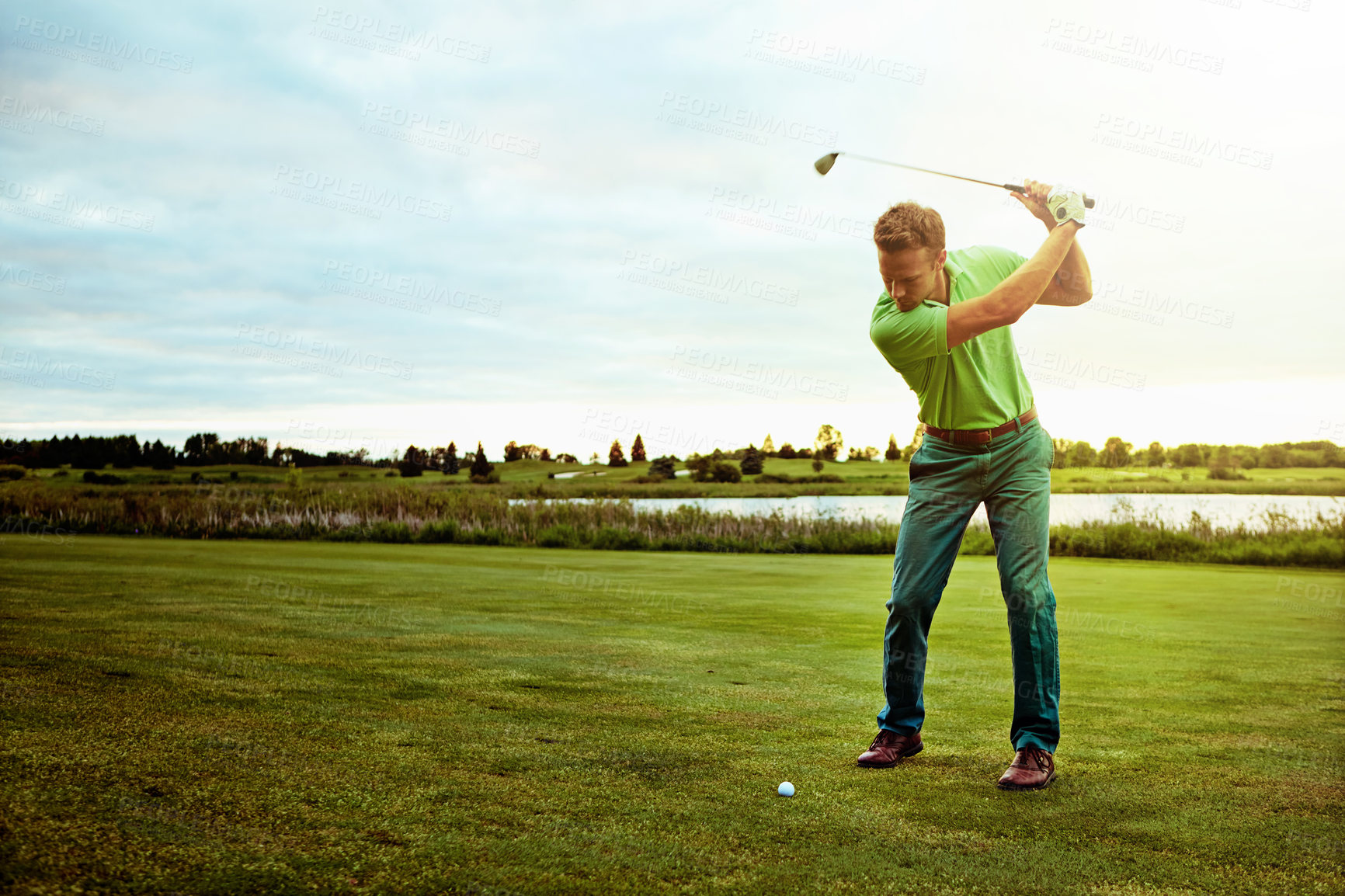 Buy stock photo Shot of a man practicing his swing on the golf course