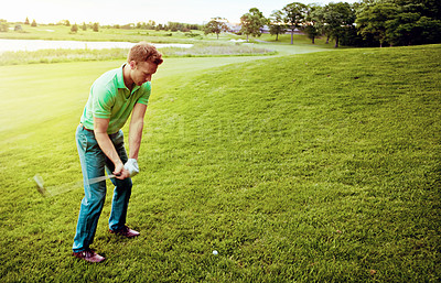 Buy stock photo Shot of a young man spending the day on a golf course