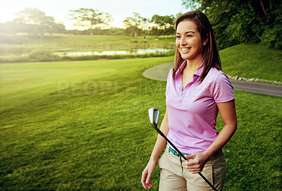 Buy stock photo Shot of a young woman spending the day on a golf course