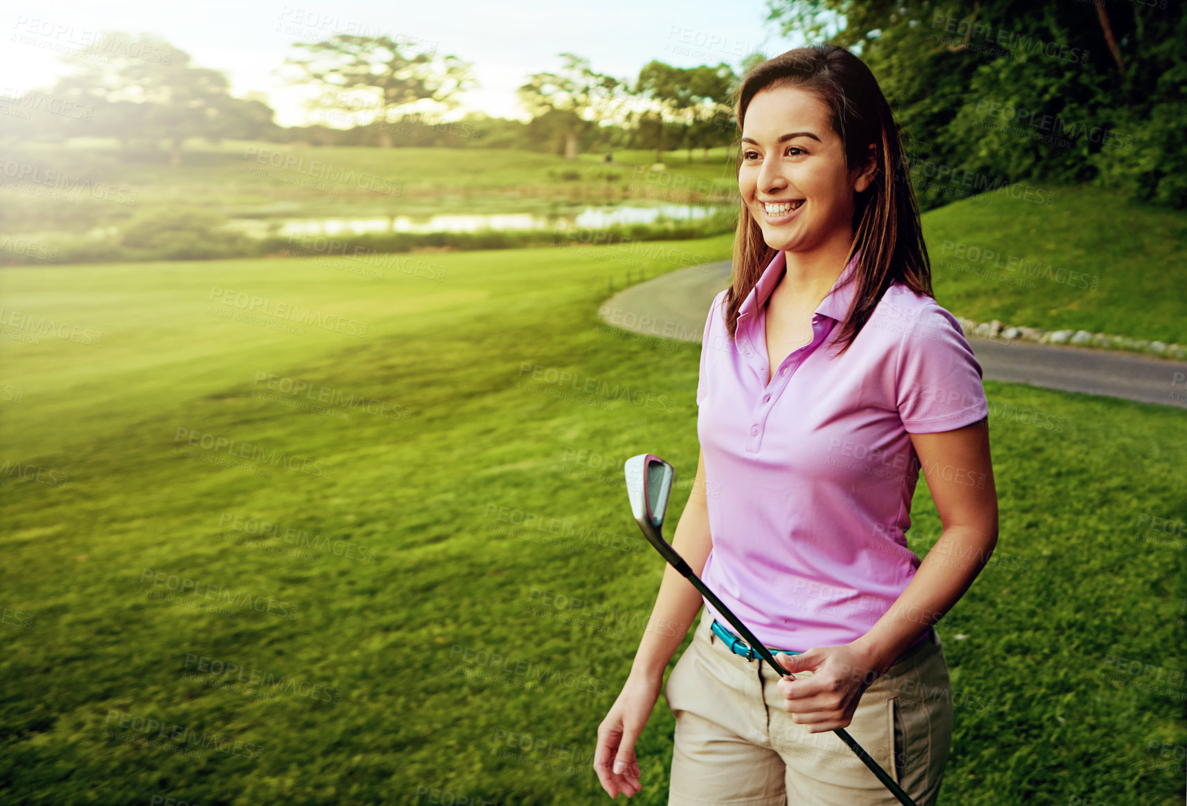 Buy stock photo Shot of a young woman spending the day on a golf course