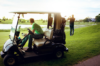 Buy stock photo Shot of a man watching his friend play golf while sitting in a golf cart