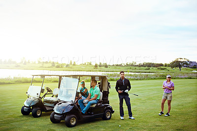 Buy stock photo Shot of a group of friends playing a round of golf on a fairway