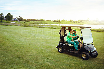 Buy stock photo Shot of a couple riding in a golf cart on a golf course