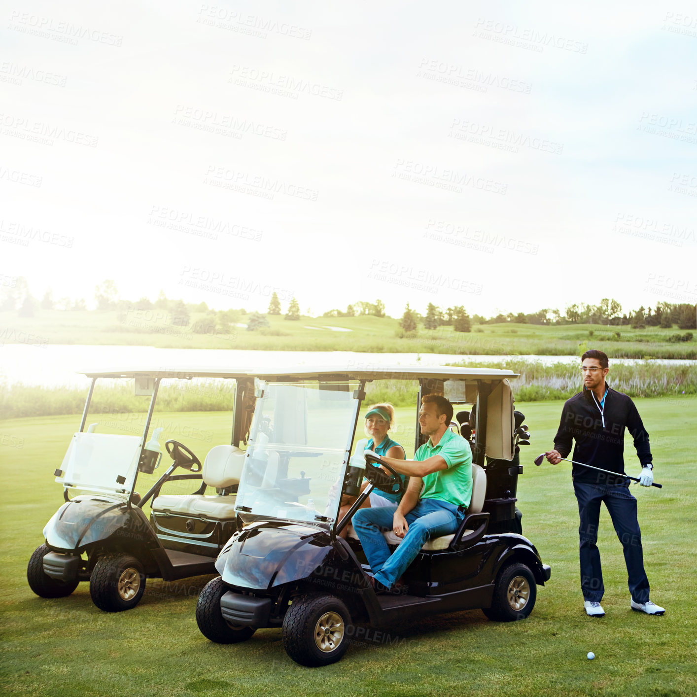 Buy stock photo Shot of a group of friends playing a round of golf on a fairway