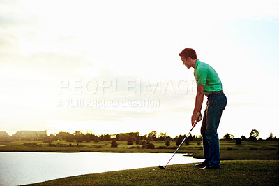 Buy stock photo Shot of a young man spending the day on a golf course