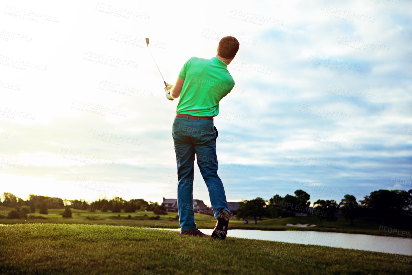 Buy stock photo Rearview shot of a man practicing his swing on the golf course