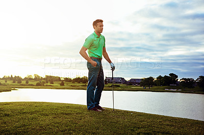 Buy stock photo Shot of a young man spending the day on a golf course