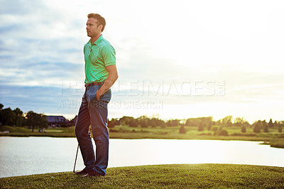 Buy stock photo Shot of a young man spending the day on a golf course