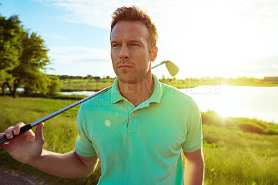 Buy stock photo Shot of a young man spending the day on a golf course