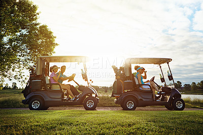 Buy stock photo Shot of a group of friends riding in a golf cart on a golf course