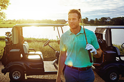 Buy stock photo Shot of a young man spending the day on a golf course