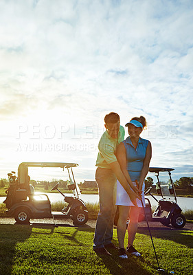 Buy stock photo Shot of a husband helping his wife play golf