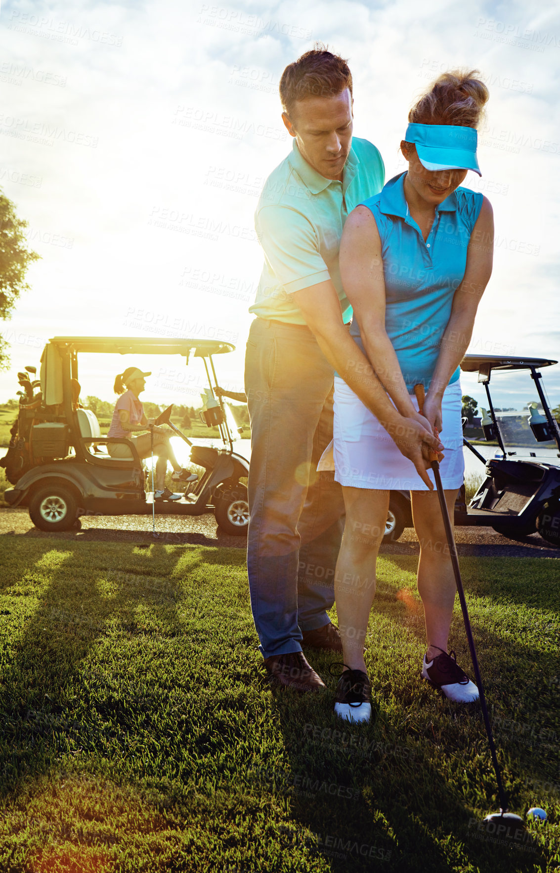 Buy stock photo Shot of a husband helping his wife play golf