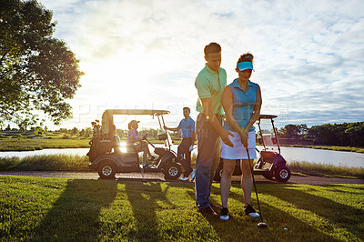 Buy stock photo Shot of a husband helping his wife play golf