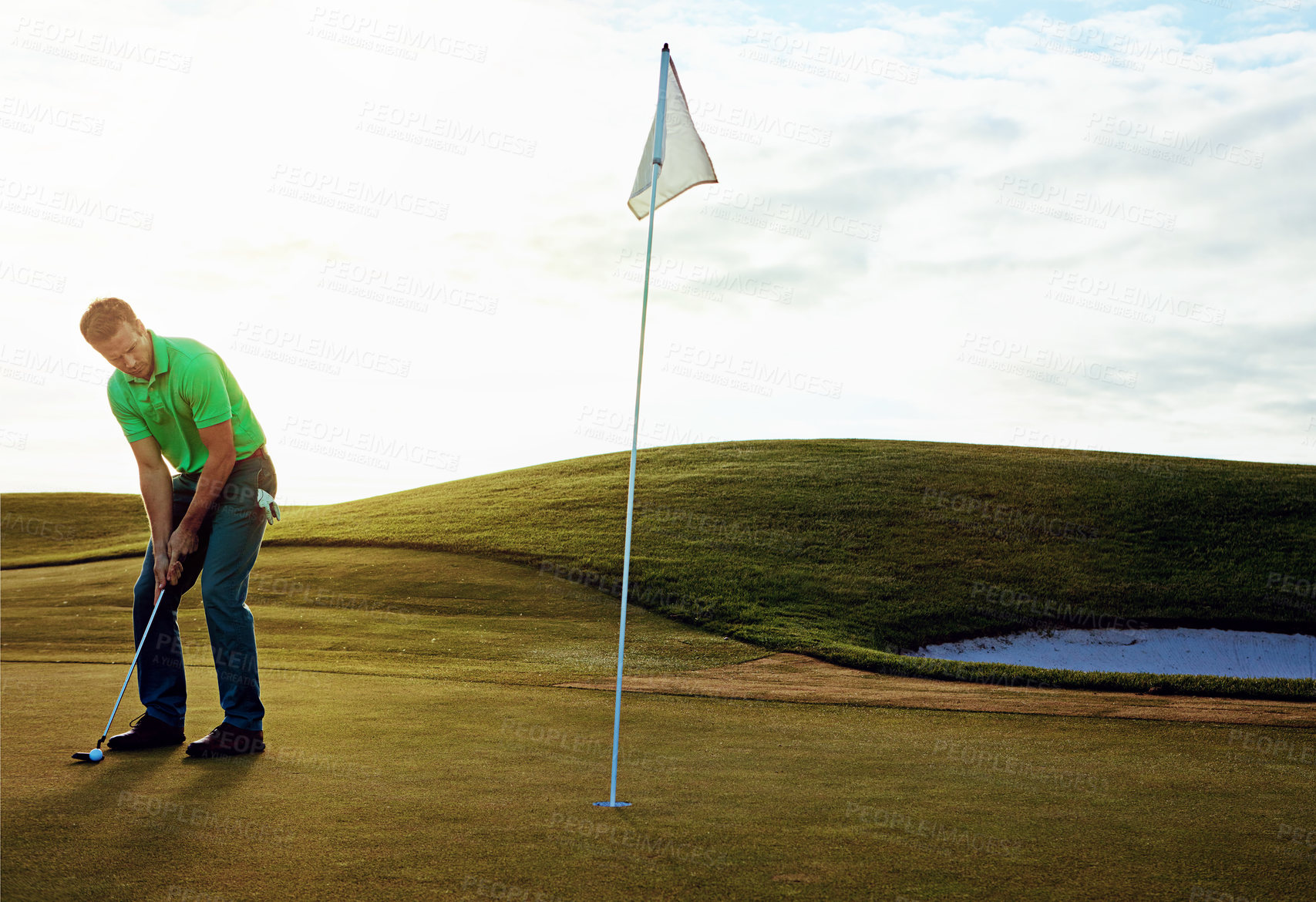 Buy stock photo Shot of a young man spending the day on a golf course