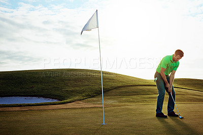 Buy stock photo Shot of a young man spending the day on a golf course