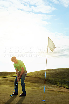 Buy stock photo Shot of a young man spending the day on a golf course