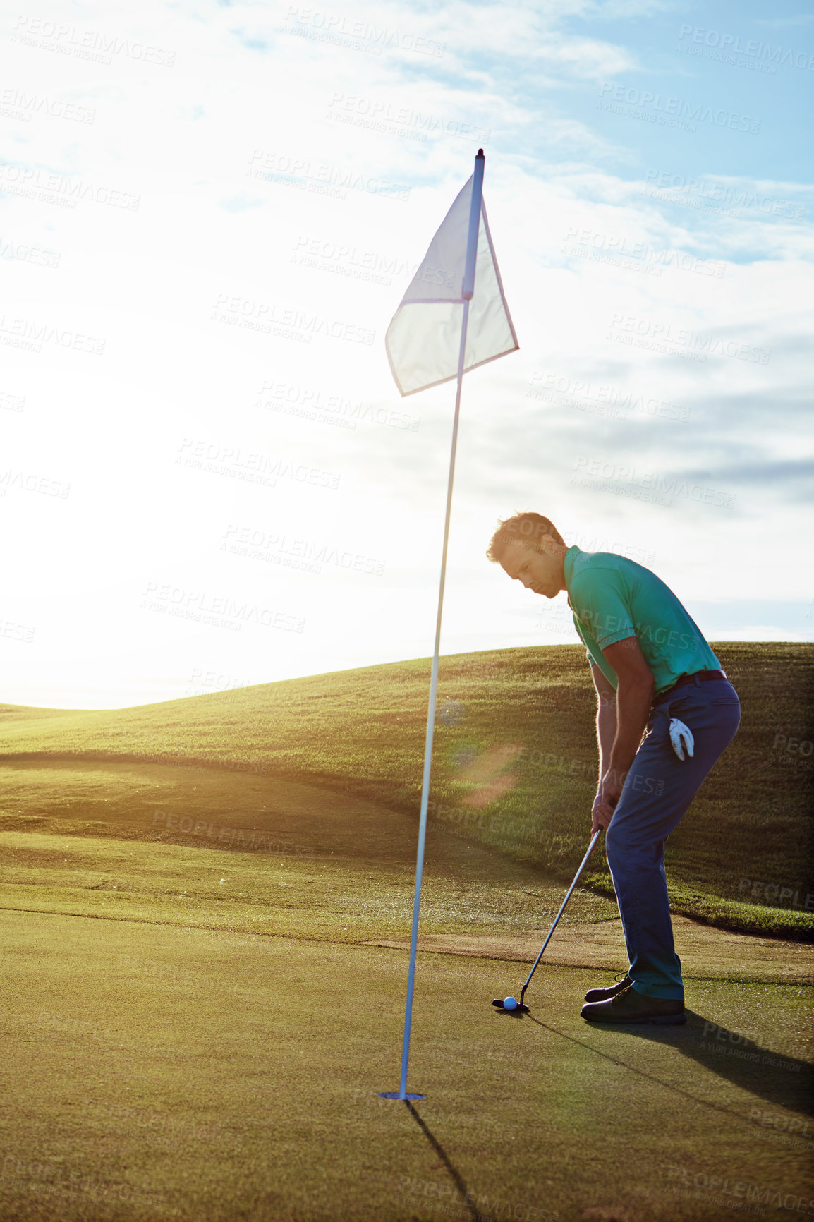 Buy stock photo Shot of a young man spending the day on a golf course