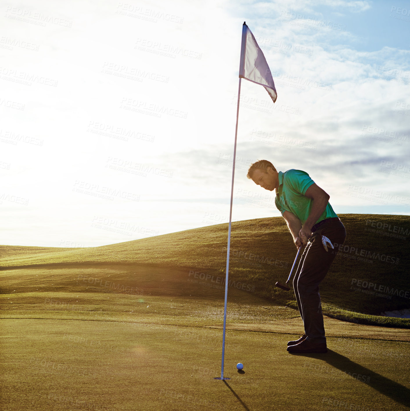 Buy stock photo Shot of a young man spending the day on a golf course