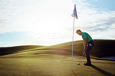 Buy stock photo Shot of a young man spending the day on a golf course