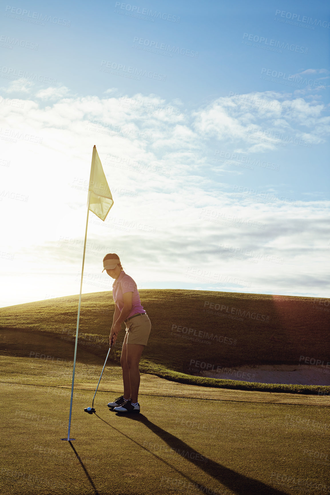 Buy stock photo Shot of a woman playing golf on a sunny day