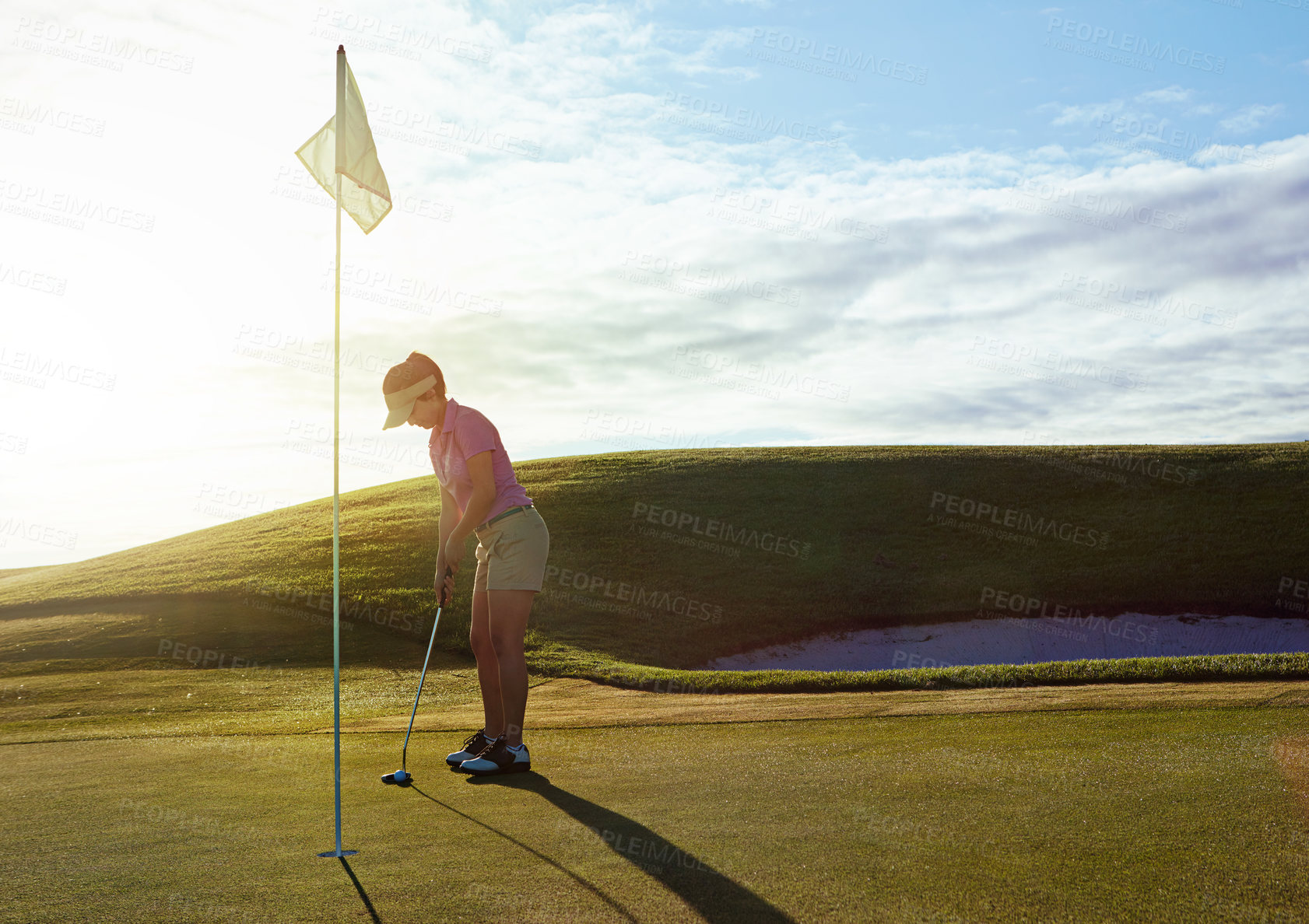 Buy stock photo Shot of a woman playing golf on a sunny day