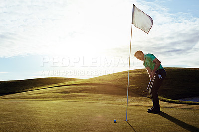 Buy stock photo Shot of a young man spending the day on a golf course