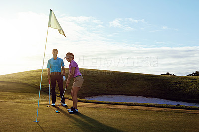 Buy stock photo Shot of a couple playing golf together on a fairway