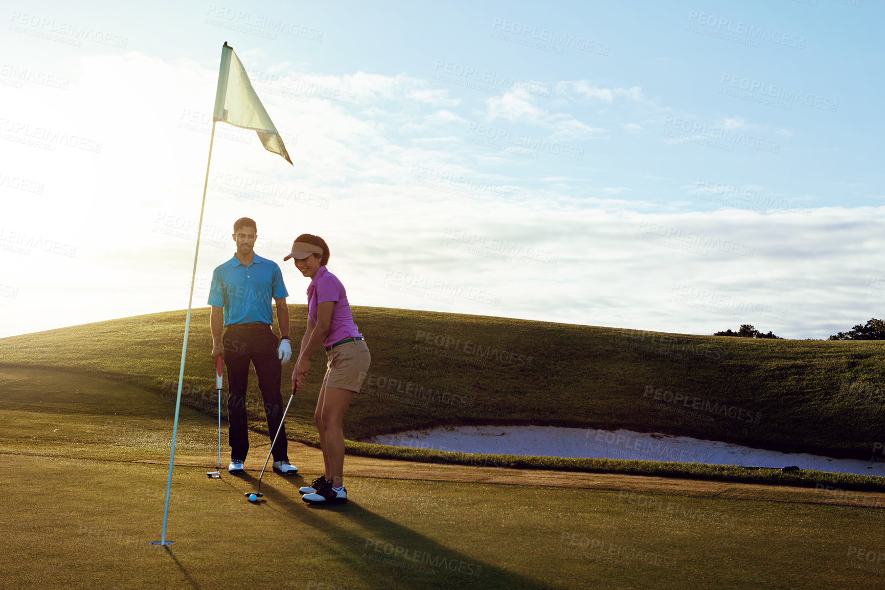 Buy stock photo Shot of a couple playing golf together on a fairway