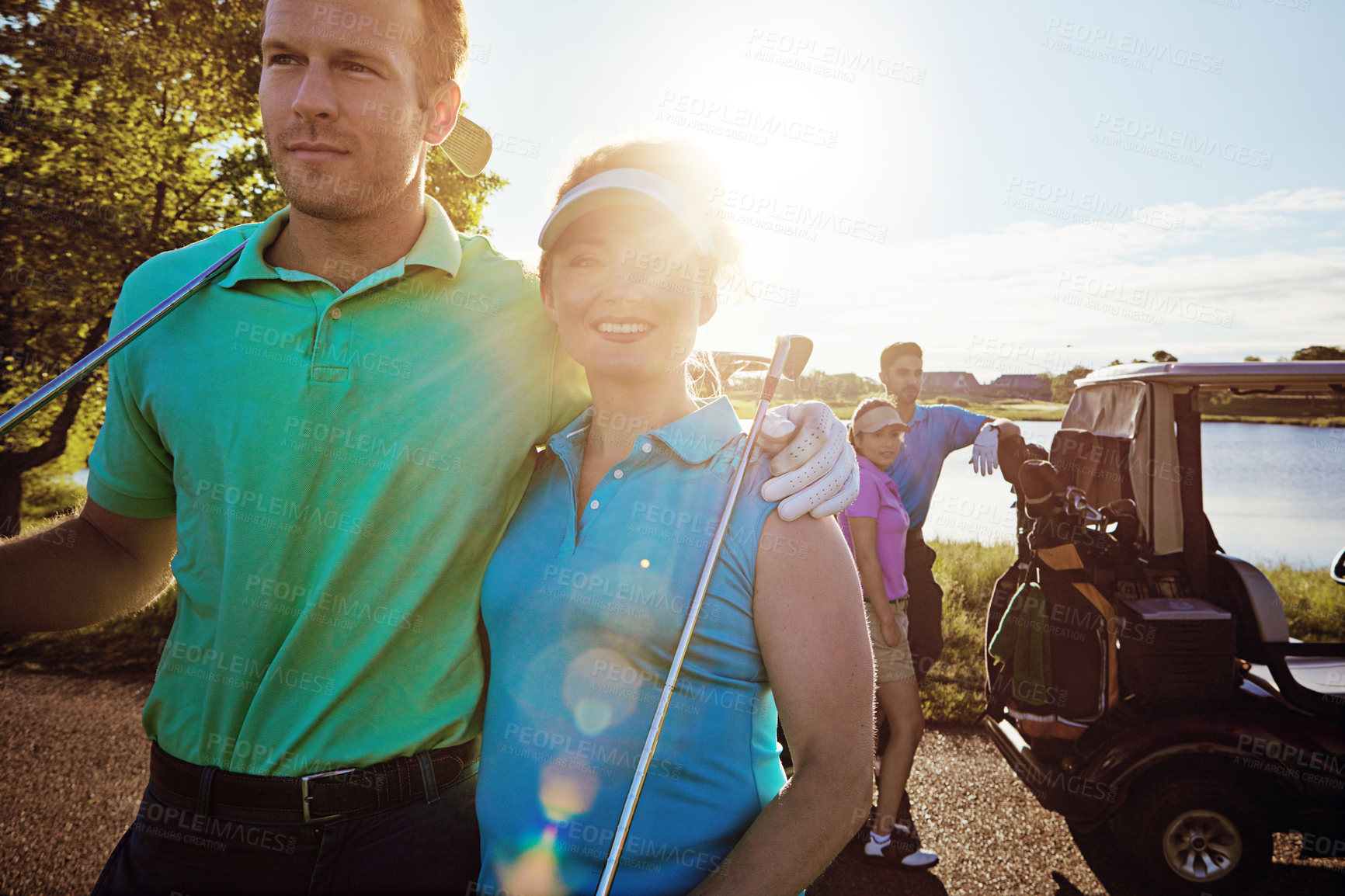 Buy stock photo Shot of two couples playing a round of golf together on a sunny day