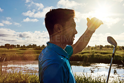 Buy stock photo Shot of a young man spending the day on a golf course