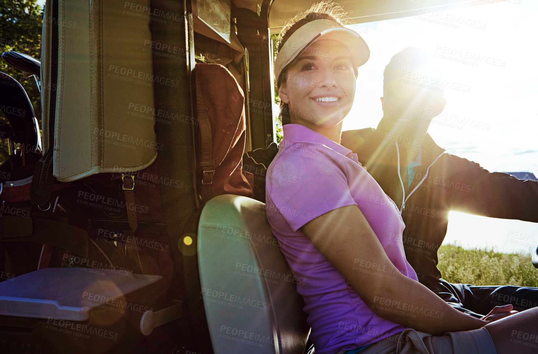 Buy stock photo Shot of a couple riding in a golf cart on a golf course