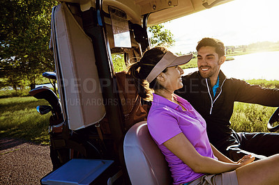 Buy stock photo Shot of a couple riding in a golf cart on a golf course