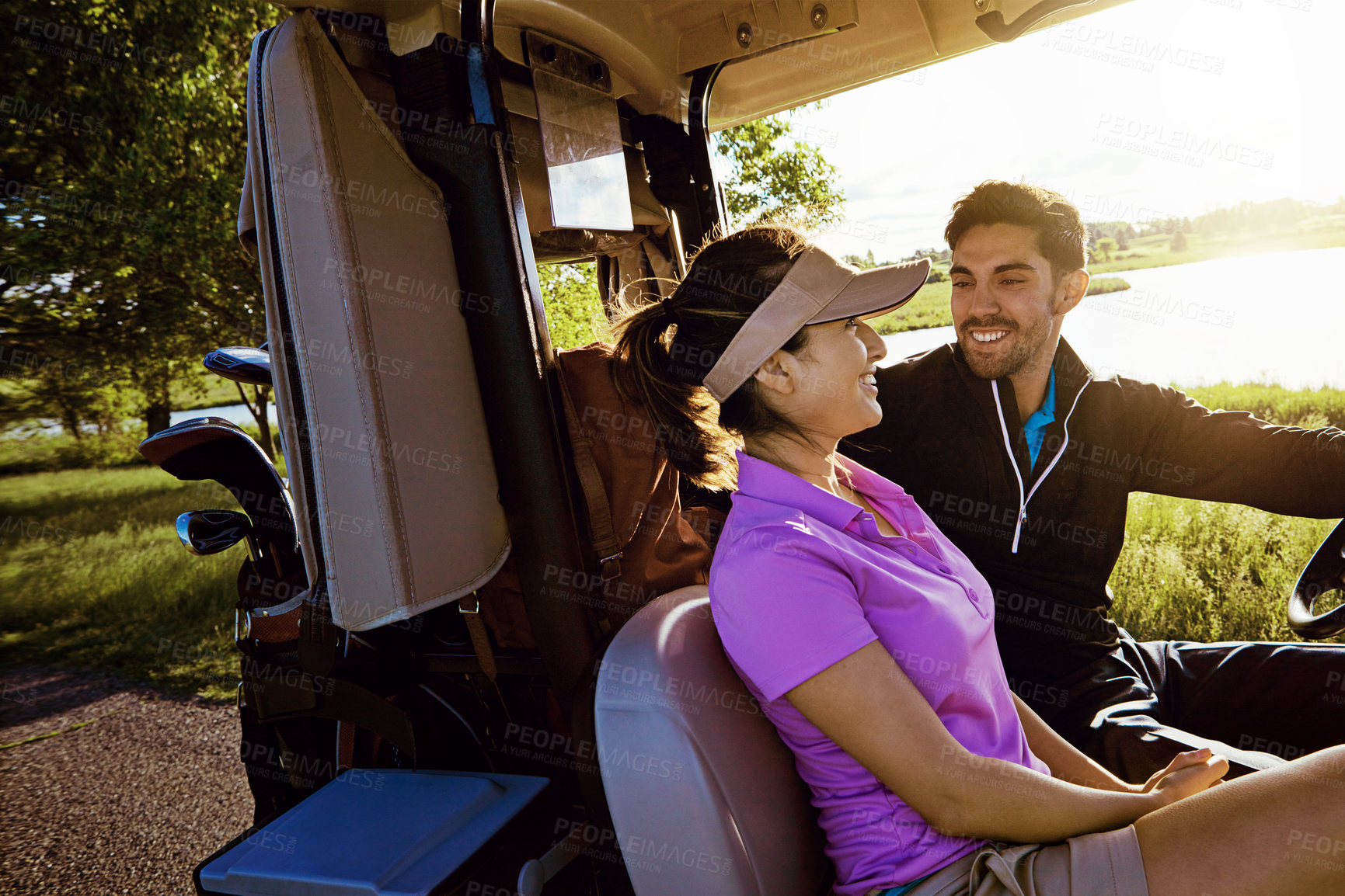 Buy stock photo Shot of a couple riding in a golf cart on a golf course