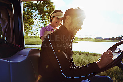 Buy stock photo Shot of a man writing on a score card while out for a game of golf with his wife