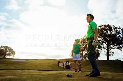 Buy stock photo Shot of a couple playing golf together on a fairway